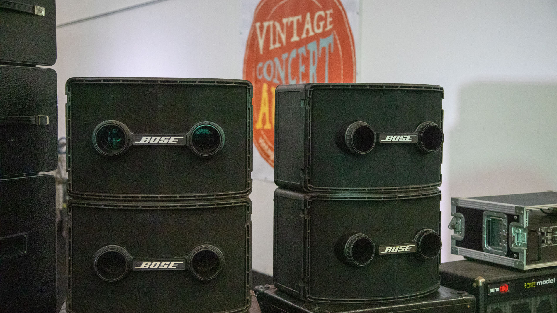 A man stands in front of old concert sound systems